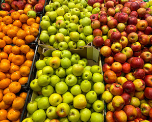 Apples and tangerines in boxes on the counter in the supermarket. Mobile Photo
