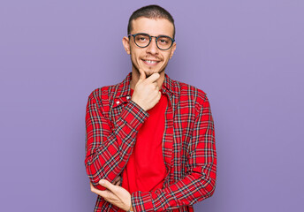 Fototapeta premium Hispanic young man wearing casual clothes looking confident at the camera smiling with crossed arms and hand raised on chin. thinking positive.