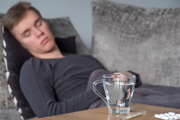 Sick man lying on the bed at home. Text space