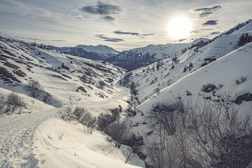 Paysage de montagne sur un chemin enneigé avec des arbres le long d'un ruisseau dans la vallée Perdue à la Toussuire dans les Alpes