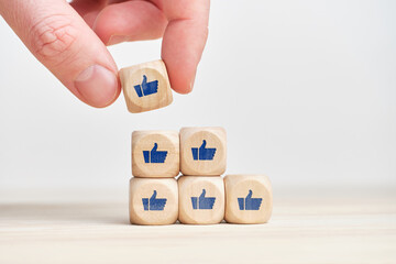 The concept of increasing popularity. Development of awareness. Cubes with thumbs up and likes.