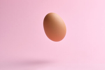 Flying egg on pink background. Happy easter concept.