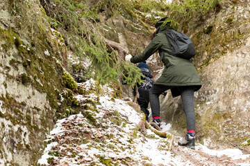 A women and child climbing a mountain in woods. Healthy living concept, family time and body care.