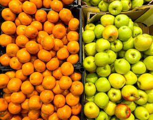 Apples and tangerines in boxes on the counter in the supermarket. Mobile Photo