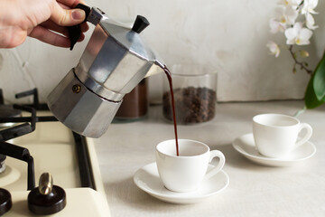 Coffee is poured from the geyser coffee maker into the espresso cup. The concept of making coffee...