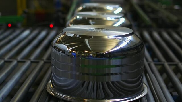 In the steel pot making factory, the finished pots go to be packed on rails. slow motion .4K.