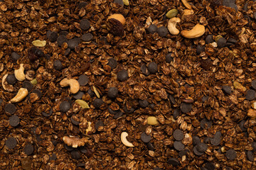 Chocolate granola cereal with nuts background.