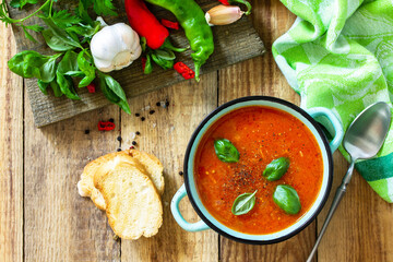 The concept of healthy and diet food, vegetarian dish. Tomato soup or gazpacho soup with croutons on a wooden rustic table.