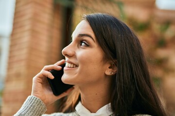 Young hispanic woman smiling happy talking on the smartphone at the city.