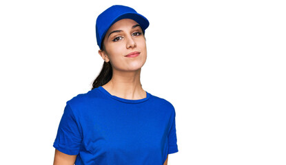 Young hispanic girl wearing delivery courier uniform relaxed with serious expression on face. simple and natural looking at the camera.