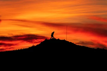 Fotobehang Warm oranje Ataturk silhouette. Climb the mountain with a magnificent cloudy sky sunset.