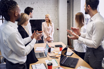 Concentrated business people applaud their colleague after the presentation in the board room