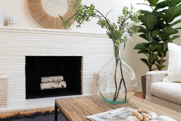 Detail of flower arrangement in modern living room space with white brick fireplace.