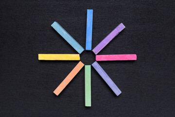colored crayons stacked with a star on a black background