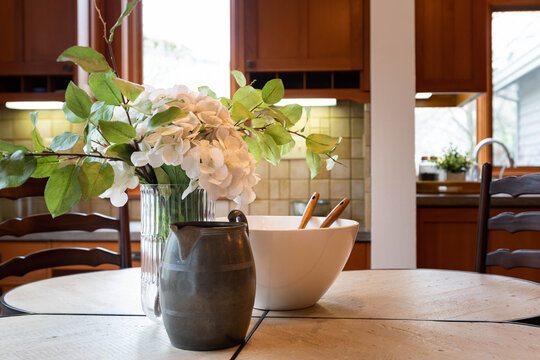 Kitchen Vignette With Flower Arrangement And Mixing Bowl On Rustic Kitchen Table.