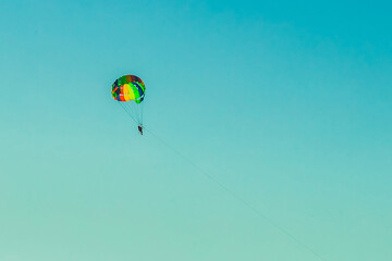 A man and a woman tourists are parachuting against the blue sky. Extreme vacation concept