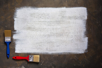Painted background texture of abstract surface and paintbrush. White paint background