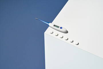 Medicine concept. Medical thermometer. Blue and white cube. Flu pills. Healthcare supplement. Fever sick. Aspirin. Pharmaceutical laboratory. Antibiotic home treatment. Copyspace