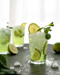 Cold tea with ice, lime in glass glasses. Refreshing beverage, summer mood. Mojito.