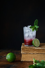 Cocktail with Malina, Mint and Ice on old books