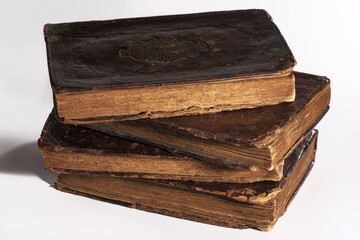 Stack of old worn out leather-bound books isolated on white background. Closeup.