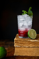 Cocktail with Malina, Mint and Ice on old books