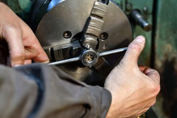 A turner cuts a thread with a lathe on a lathe.
