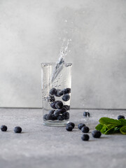 Glass with water and blueberry, splashes and bubbles