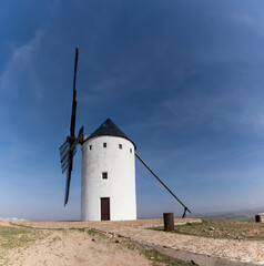 whitewashed historic windmill typical of the La Mancha region of central Spain under a blue sky