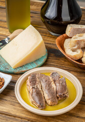 Fish, olive oil, parmesan cheese, bread and wine over wooden table. Mediterranean food