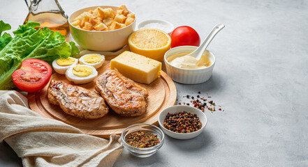 A set of products for making Caesar salad on a gray background with space for copying.