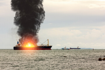 Large general cargo ship for logistic import export goods and other the explosion and had a lot of fire and smoke at sea