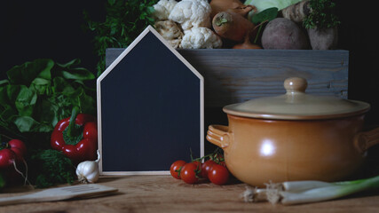 Empty blackboard copy space next to clay cooking pot and fresh vegetable vegetarian home cooking © Lupsa Florin