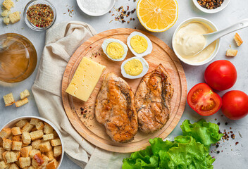 Kitchen table with ingredients for making Caesar salad. Top view.