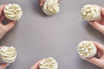 Milky cream cupcake. Birthday sweet bakery. Cookies. Yummy buttercream dessert. Wedding party food. Grey background. Holiday recipe. Anniversary gourmet. Many pieces in hands