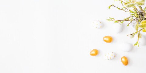 Flat lay easter composition with willow branches in a vase and easter eggs on a light background
