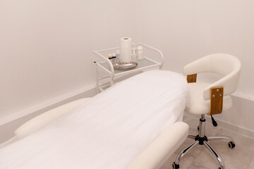 Cosmetologist's empty office with care cosmetics and massage table in a modern beauty salon.