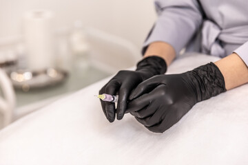 Doctor's hands in black glove with syringe.