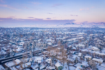 winter dawn over residential area of city of Fort Collins, Colorado, after heavy snowstorm - aerial view