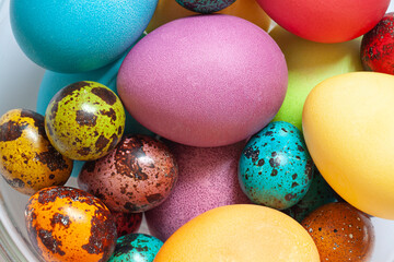 Colorful painted Easter eggs in the glass bowl on the white background. Close up	