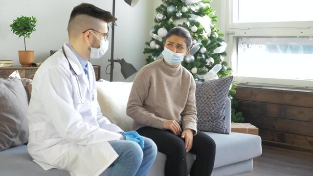 Male Doctor In A Mask And Glasses And A Woman In A Mask, A Sick Patient At Home. Health Visitor Examining A Senior Woman During Home Visit.