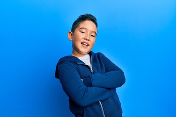 Little boy hispanic kid wearing casual sporty jacket happy face smiling with crossed arms looking at the camera. positive person.