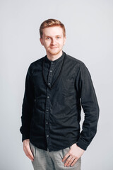Portrait of a young man in a black shirt on a white background. Copy, empty space for text