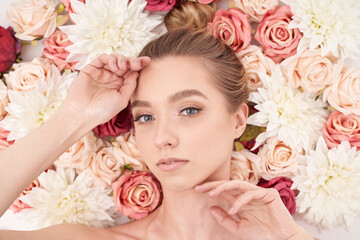 Beautiful white girl with flowers. Stunning blonde girl with big bouquet flowers of roses.  © Bartosz