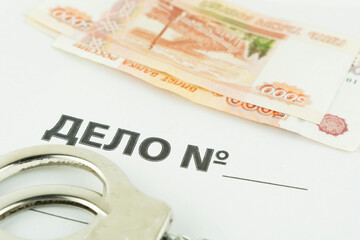folder and label dealing with handcuffs and money.translation: business