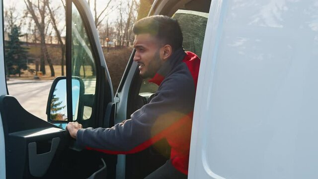 Young indian driver getting out of the van and stretching. High quality 4k footage