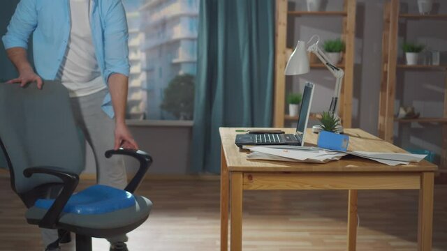 man office worker or freelancer puts a seat cushion pillow for office chair