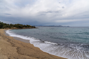 golden sand beach on the French Riviera under an expressive overcast sky
