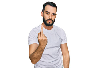 Young man with beard wearing casual white t shirt showing middle finger, impolite and rude fuck off expression