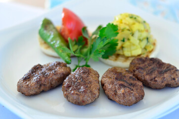 turkish meatballs with vegetables on white dish